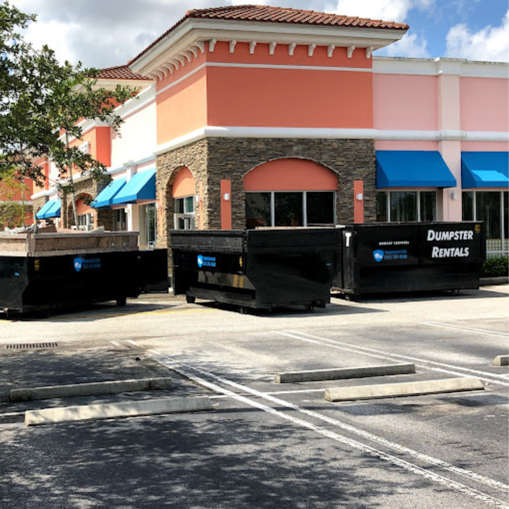 a variety of different dumpster rental sizes placed outside of a building